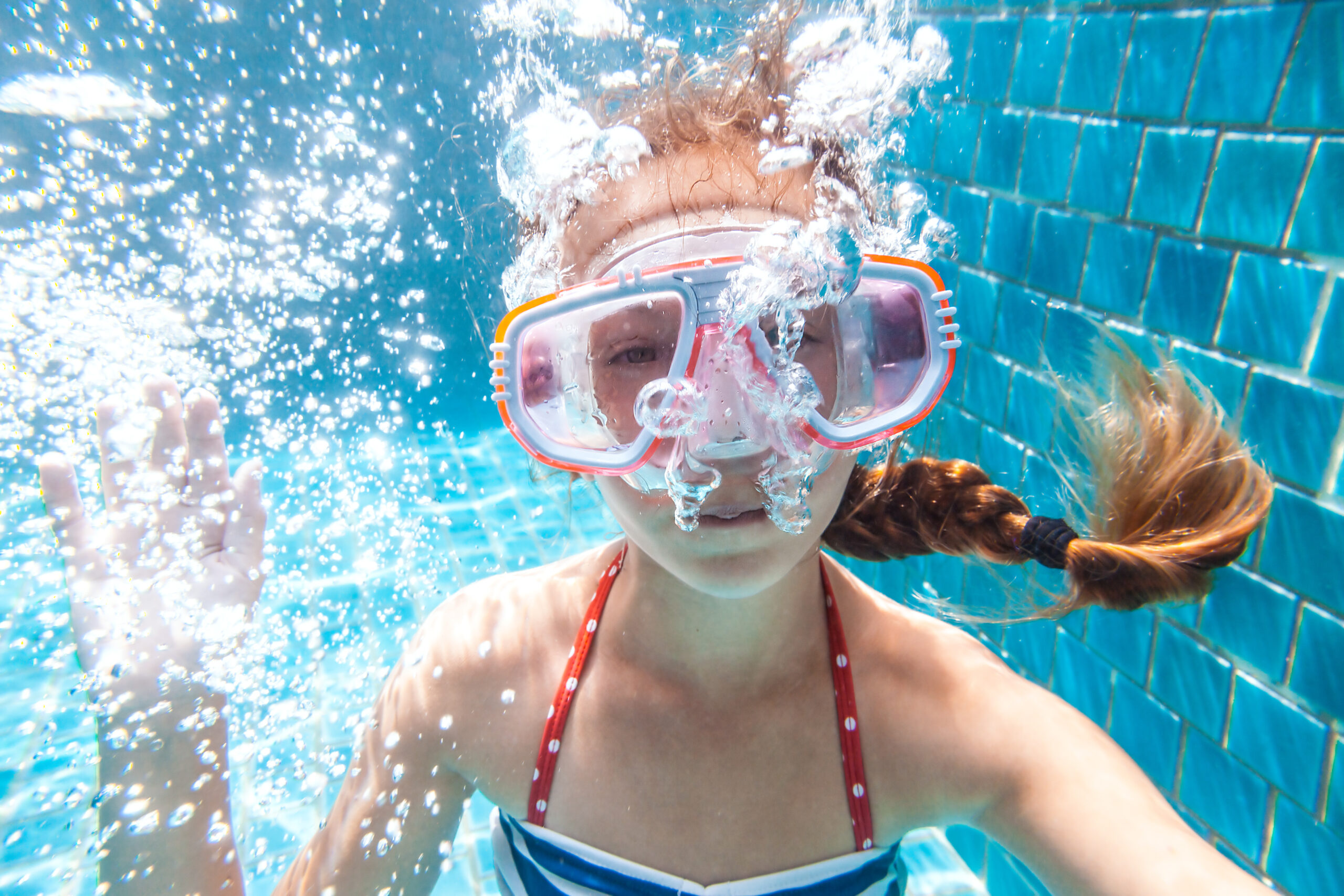 Girl swimming underwater with mask