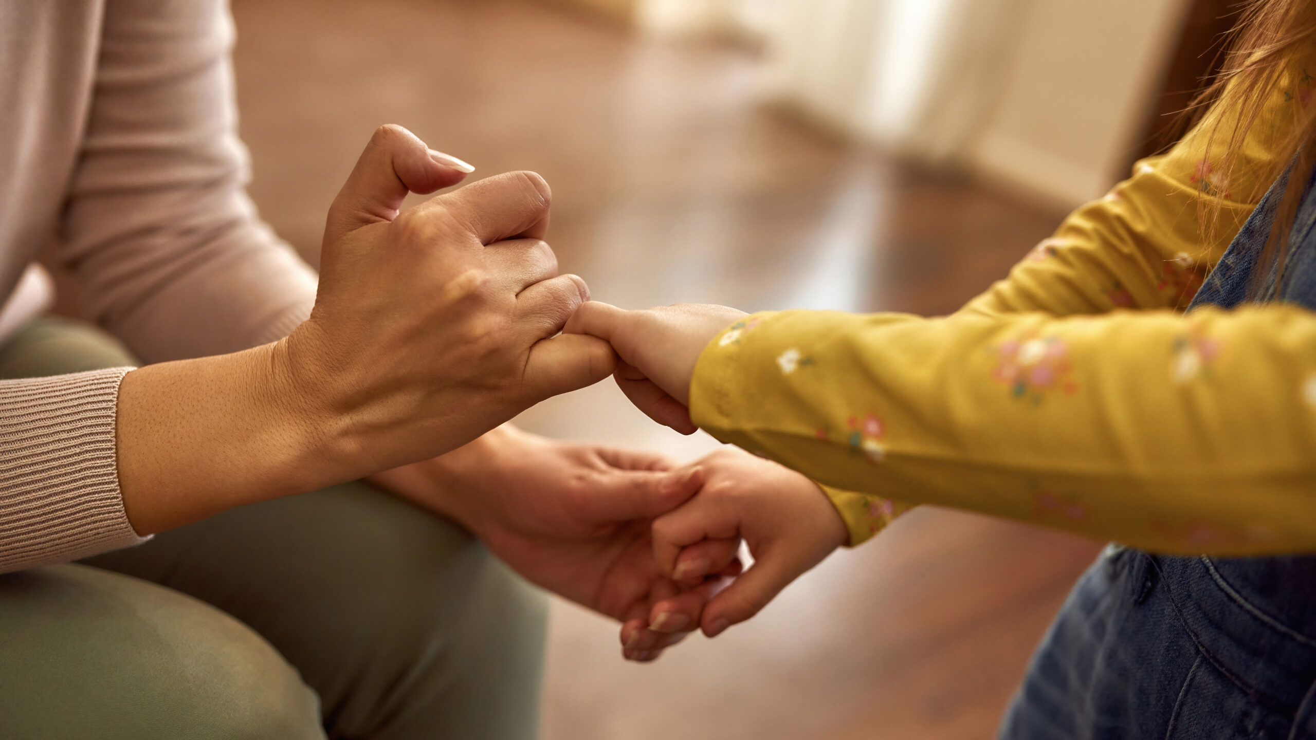 parent and child making a promise with their hands