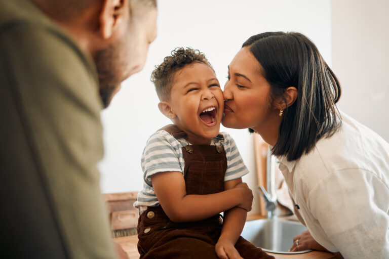 Mother kissing her son on the cheek