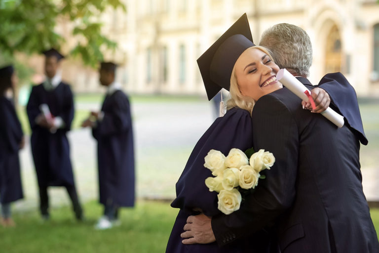 girl graduating college and hugging dad