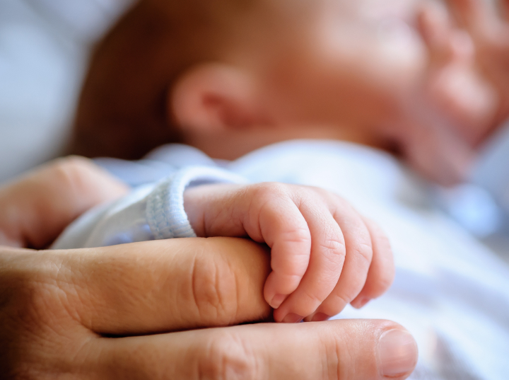 newborn baby hand holding onto mom's hand