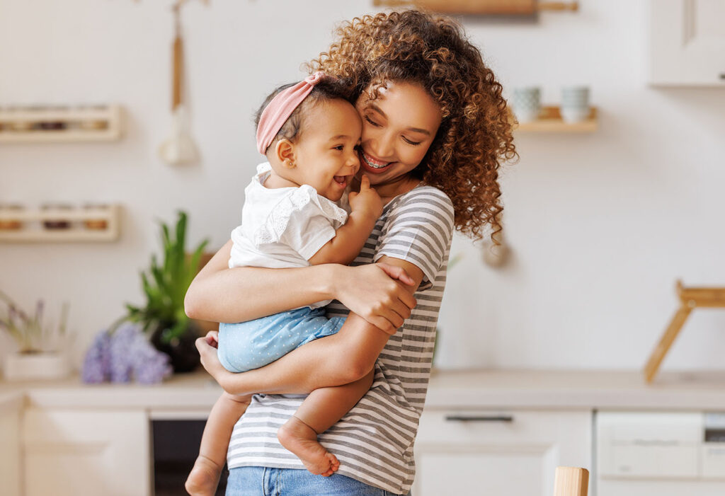 Mom holding and snuggling a baby that is laughing