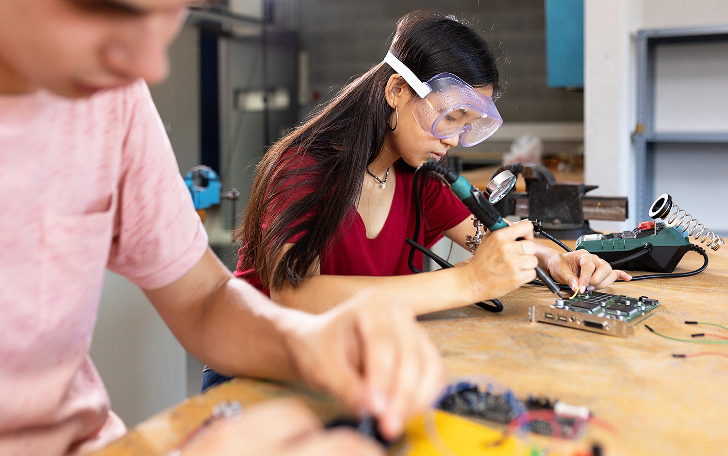 Young asian female student building robot in engineering class at high school