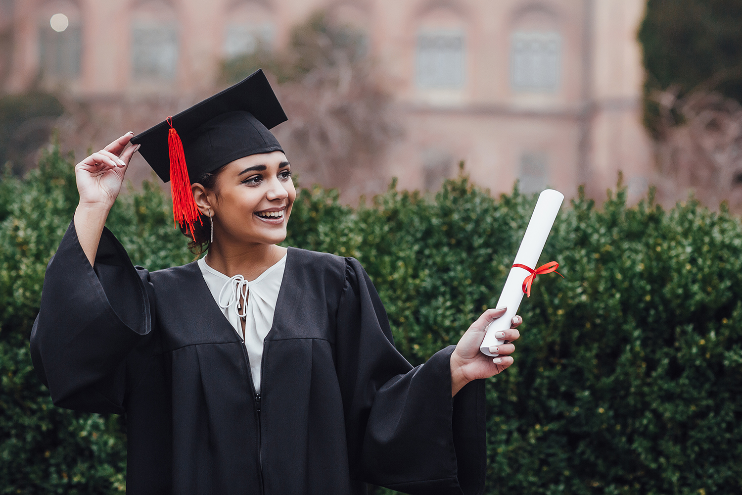 teen girl in cap and gown and getting diploma