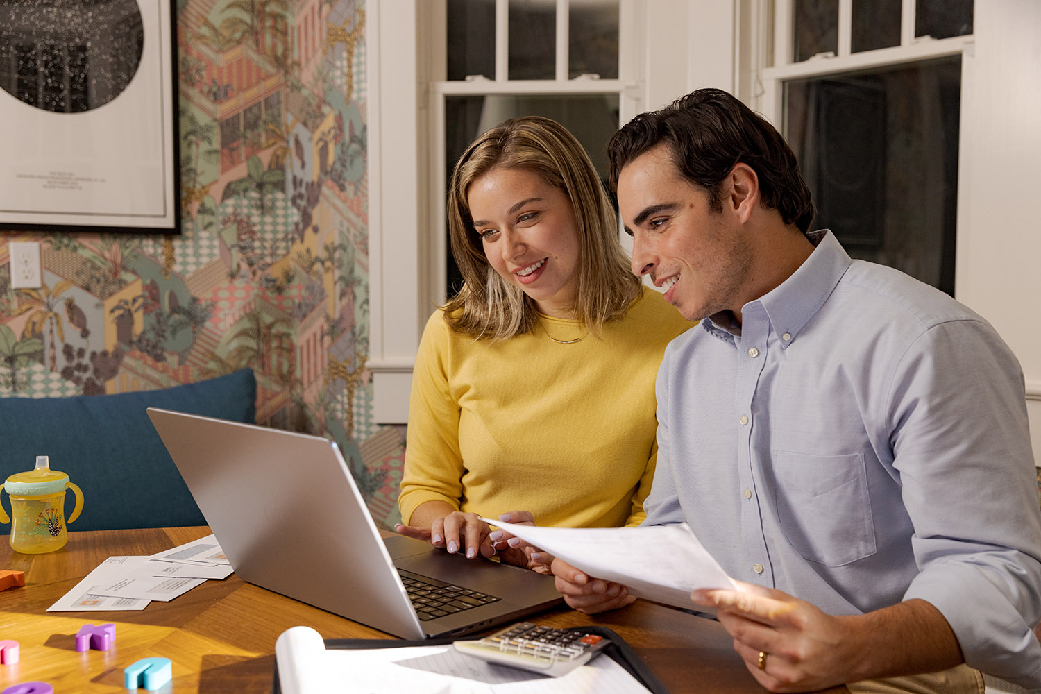 husband and wife on computer with paperwork