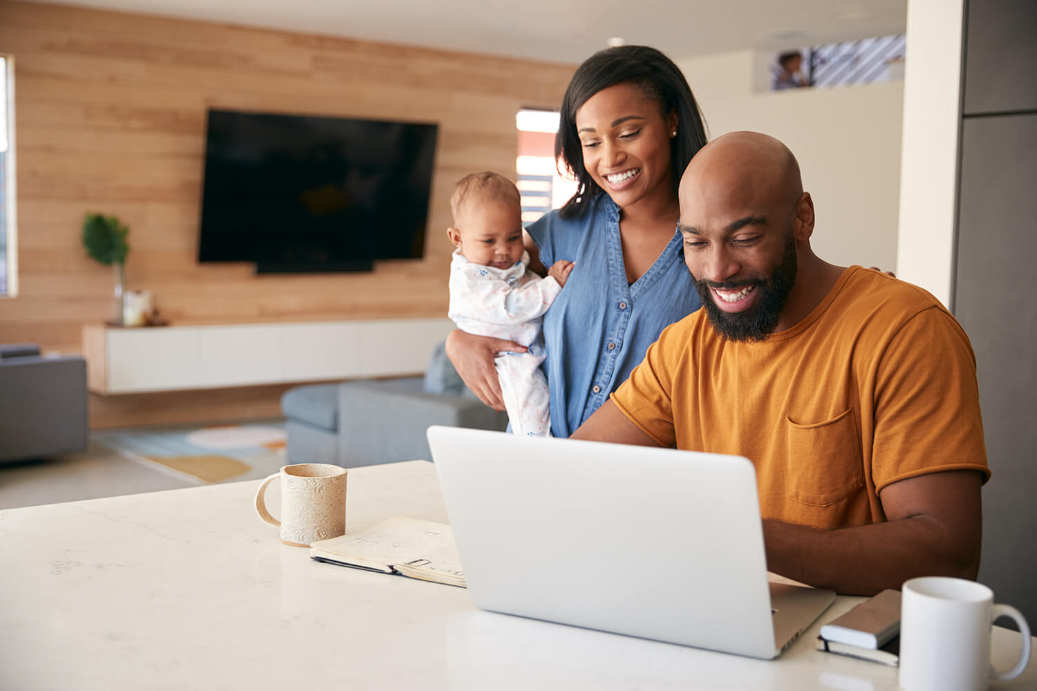 african american mom and dad with baby daughter using laptop