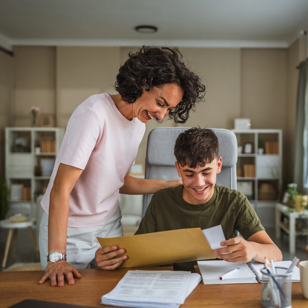 mom and son using laptop and looking at paperwork