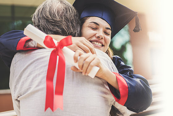 Happy college graduate hugging her father